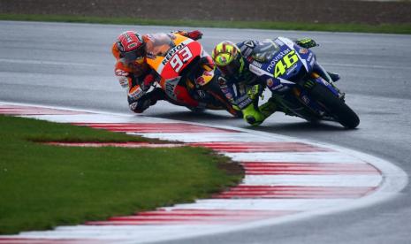 Legenda MotoGP Valentino Rossi (kanan) dalam kejaran rivalnya Marc Marquez pada sebuah balapan MotoGP di Silverstone, Inggris, Agustus 2015 silam. 