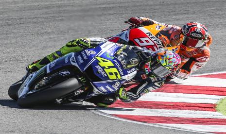 Valentino Rossi (kiri) melaju di depan Marc Marquez dalam sebuah balapan sengit yang melegenda di San Marino, Italia, pada September 2014 silam. 