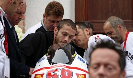 Legenda MotoGP Valentino Rossi memegangi motor almarhum Marco Simoncelli saat upacara pemakaman di Rimini, Italia, 27 Oktober 2011.