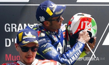 Valentino Rossi menunjukkan helmnnya yang bertuliskan 'Italia' di Mugello Circuit, Ahad (3/6).