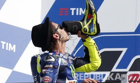 Valentino Rossi minum menggunakan sepatu boot-nya di podium  Balapan MotoGP San Marino 2016