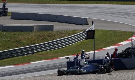 Valtteri Bottas keluar dari mobilnya setelah menabrak pembatas dalam sesi latihan bebas kedua GP Austria, Jumat (28/6).