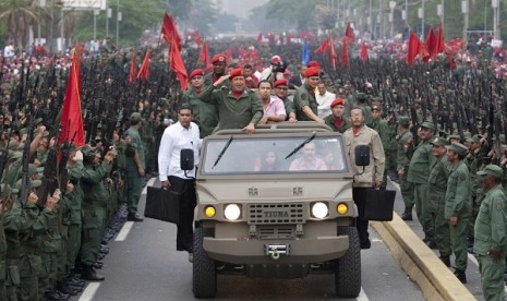 Venezuela's President Hugo Chavez salutes militia members as he arrives for a ceremony to commemorate the eighth anniversary of his return to power after a brief coup, in Caracas in this April 13, 2010 file photo. 