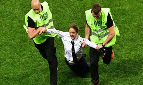 Veronika Nikulshina saat diamankan petugas setelah menerobos ke lapangan saat laga final Piala Dunia 2018.