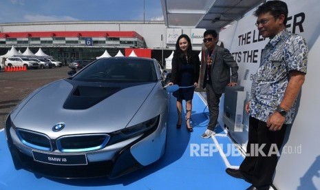 Vice President Corporate Communications BMW Group Indonesia Jodie O'tania (kiri), Direktur PT Dyandra Promosindo Hendra Noor Saleh (tengah) dan Direktur Marketing PT Sky Energi Indonesia Ronald Sibarani mengisi daya listrik mobil BMW i8 dengan alat BMW i Wallbox Plus dalam Festival Mobil Listrik, IIMS 2018 di JIExpo, Jakarta, Jumat (20/4). 