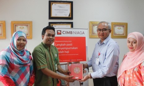 Vice President Corporate Planning & Management Head  Syariah Banking  CIMB Niaga Syariah Rudi Amir (kedua dari kanan) menyerahkan wakaf Alquran kepada Manajer Program Pemberdayaan BMH  M Fahrurrozi (kedua dari kiri).