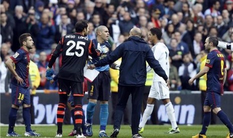 Victor Valdes (tengah), kiper Barcelona, memprotes keputusan wasit saat menghadapi Real Madrid di laga La Liga di Santiago Bernabeu, Madrid, Sabtu (2/3).