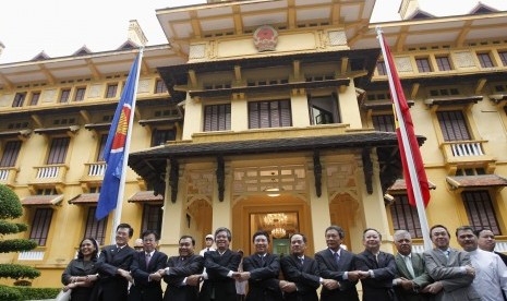 Vietnam's Foreign Minister Pham Binh Minh (center L), Vice Foreign Ministers Pham Quang Vinh (5th L) and Le Luong Minh (Center R) pose for a photo with ASEAN ambassadors to Vietnam in Hanoi August 8, 2012. They were attending a flag raising ceremony to mar