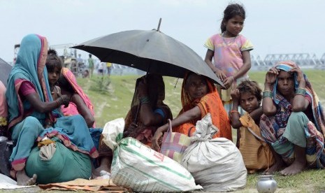 Villagers with their belongings sit in a relief camp after their evacuation at Supaul district in the eastern Indian state of Bihar August 3, 2014. More than 400,000 people in eastern India face the risk of flooding after a landslide that killed at least n