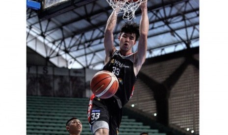 Vincent Rivaldi Kosasih melakukan dunk saat menghadapi Satya Wacana Salatiga dalam laga pembuka Seri I Pertalite IBL 2017.