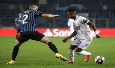 Vinicius Junior dari Real Madrid (kanan) ditantang oleh Rafael Toloi dari Atalanta di babak 16 besar Liga Champions, dalam pertandingan leg pertama antara Atalanta melawan Real Madrid, di Stadion Gewiss, Bergamo, Kamis (25/2) dini hari WIB.