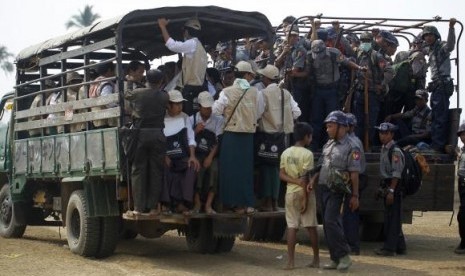 Volunteers and police board vehicles before proceeding to Rohingya refugee camps to collect data for the census in Sittwe March 31, 2014.