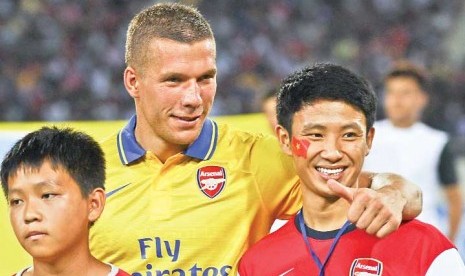 Vu Xuan Tien (kanan) bersama pemain Arsenal Lukas Podolski.