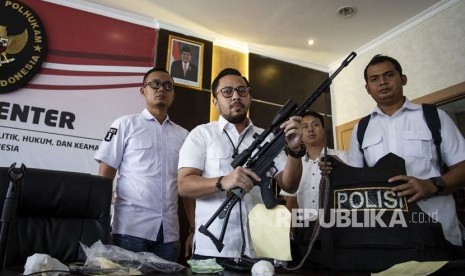 Wadir Reskrimum Polda Metro Jaya AKBP Ade Ary Syam menunjukkan barang bukti senjata api dan rompi anti peluru seusai menggelar konferensi pers perkembangan kondisi terkini keamanan nasional di kantor Kemenko Polhukam, Jakarta, Senin (27/5/2019).