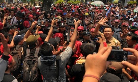 Wagub DKI Jakarta, Basuki Tjahaja Purnama atau Ahok (kanan) menyapa para buruh yang menggelar aksi unjuk rasa di depan Gedung Balai Kota, Jakarta, Rabu (24/10). Para buruh menuntut upah layak dan mendesak Pemerintah DKI Jakarta, untuk menghapuskan sistem 