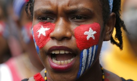 Wajah pengunjuk rasa digambar bendera kejora di aksi dekat Istana, Rabu (28/8). Aksi dilakukan oleh mahasiswa Papua Barat sebagai protes atas insiden rasis. 