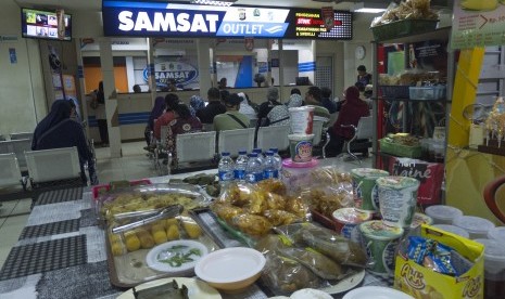 Wajib pajak menunggu pengurusan perpanjangan Surat Tanda Nomor Kendaraan (STNK) di Samsat Outlet di pusat perbelanjaan ITC Depok, Jabar, Kamis (30/3). 