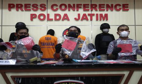 Wakapolda Jawa Timur Brigjen Pol Slamet Hadi Supraptoyo (tengah) menunjukkan barang bukti kasus penggelapan emas di Polda Jawa Timur, Surabaya, Jawa Timur, Jumat (8/10/2021). Ditreskrimum Polda Jawa Timur menangkap tersangka DJ (38) atas kasus dugaan penggelapan emas dari tempat kerjanya, serta SB (34) atas kasus dugaan penadahan hasil penggelapan dari tersangka DJ dengan barang bukti diantaranya emas batangan dengan berat tujuh kilogram.