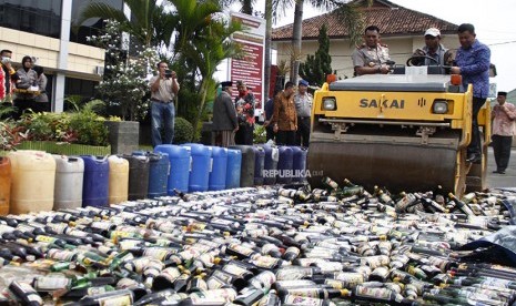 Wakapolda Lampung Brigjen Pol. Angesta Romano Yoyol bersama Plt Walikota Bandar Lampung Yusuf Kohar naik alat berat ketika memusnahkan barang bukti ribuan botol minuman keras (miras) di Mapolresta Bandar Lampung, Jumat (20/4). 