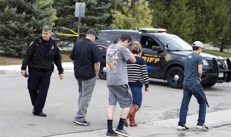 Wakil Departemen Sheriff Douglas County, Denver, Colorado mengarahkan warga kembali ke kendaraan di luar STEM School Highlands Ranch setelah terjadi penembakan di sekolah tersebut, Selasa (7/5).