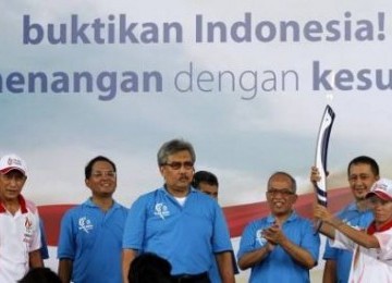 Wakil Direktur Utama Bank Mandiri Riswinandi (ketiga kiri) didampingi sejumlah direksi seusai menyerahkan api obor SEA Games XXVI kepada mantan pelari nasional, Maria Lawalata (kanan), di Plaza Mandiri, Sabtu (5/11).