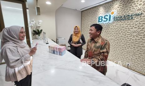 Wakil Direktur Utama BSI Bob T Ananta (kanan) berbincang dengan nasabah yang sedang bertransaksi di BSI Kantor Cabang The Tower, Jakarta, Kamis (13/3/2025).