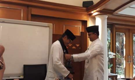 Wakil Gubernur DKI Jakarta Sandiaga Salahuddin Uno dan Gubernur DKI Jakarta Anies Rasyid Baswedan berpelukan dan bertukar syal dalam momen perpisahan di Ruang Gubernur, Balai Kota, Jalan Medan Merdeka Selatan, Jakarta Pusat, Jumat (10/8).