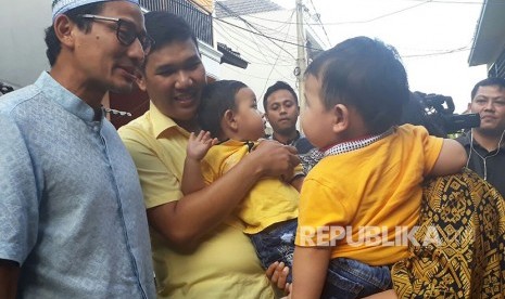 Wakil Gubernur DKI Jakarta Sandiaga Salahuddin Uno mengunjungi rumah salah seorang anggota tim patroli pengawalan (patwal) Brigadir Togu Stevenson Naibaho yang merayakan Natal di rumahnya, Komplek Pondok Maharta, Pondok Kacang Timur, Tangerang Selatan, Senin (25/12). 