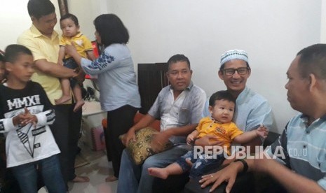 Wakil Gubernur DKI Jakarta Sandiaga Salahuddin Uno mengunjungi rumah salah seorang anggota tim patroli pengawalan (patwal) Brigadir Togu Stevenson Naibaho yang merayakan Natal di rumahnya, Komplek Pondok Maharta, Pondok Kacang Timur, Tangerang Selatan, Senin (25/12). 