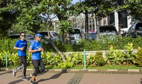 Wakil Gubernur DKI Jakarta Sandiaga Uno (kanan) berlari menuju Balai Kota, di Jakarta. 