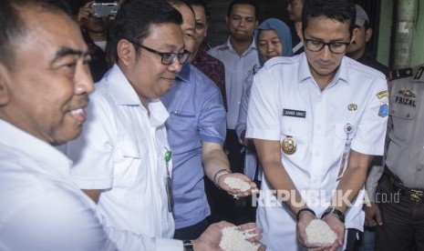 Wakil Gubernur DKI Jakarta Sandiaga Uno (kanan) bersama Direktur Utama Food Station Tjipinang Jaya Arief Prasetyo (tengah) dan Kepala Perum Bulog Drive DKI Jakarta Mansur (kiri) memeriksa kualitas beras saat meninjau aktivitas perdagangan di Pasar Induk Beras Cipinang, Jakarta, Rabu (27/12). 