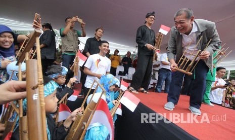  Wakil Gubernur Jabar Deddy Mizwar bersama ribuan pelajar memainkan angklung pada Angklungs Day 2017 di halaman Gedung Sate, Kota Bandung, Ahad (19/11).