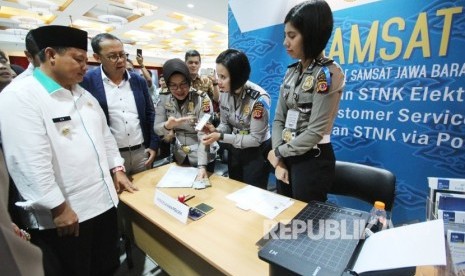 Wakil Gubernur Jawa Barat Uu Ruzhanul Ulum (berpeci) didampingi Direktur Kepatuhan dan Manajemen Risiko yang menjalankan tugas Dirut Bank BJB Agus Mulyana meninjau proses layanan Inovasi Samsat Jabar Ngabret (J'bret) di Menara Bank BJB, Kota Bandung, Kamis (27/12).