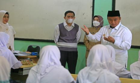 Wakil Gubernur Jawa Barat Uu Ruzhanul Ulum (kanan) berbincang dengan siswa saat meninjau kegiatan belajar mengajar di SMAN 1 Sindang, Indramayu, Jawa Barat, Senin (30/5/2022). Wagub Uu Ruzhanul Ulum meninjau pelaksanaan PTM 100 persen di Indramayu dan memberikan pengarahan kepada kepala sekolah SMA/SMK di Indramayu terkait penerapan protokol kesehatan untuk pencegahan COVID-19. 