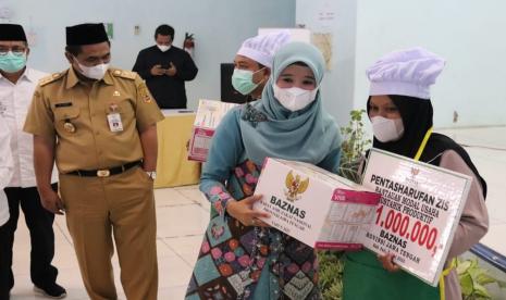 Wakil Gubernur (Wagub) Jawa Tengah, Taj Yasin Maimoen, menyerahkan bantuan secara simbolis kepada mustahik peserta pelatihan keterampilan boga bagi para mustahik, program pemberdayaan dana ZIS, kerja sama Pemprov Jawa Tengah, Baznas Jawa Tengah, Santri Gayeng Nusantara, dan SMKN Jawa Tengah, Pati, di Kabupaten Pati, Senin (6/6).