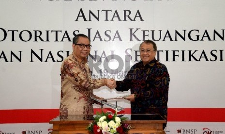 Wakil Ketua Dewan Komisioner Otoritas Jasa Keuanga (OJK) Rahmat Waluyanto (kanan) dan Ketua Badan Nasional Sertifikasi Profesi (BNSP) Sumarna F.Abdurrahman hadir saat penandatanganan nota kesepahaman antara OJK dan BNSP di Jakarta, Kamis (19/3).