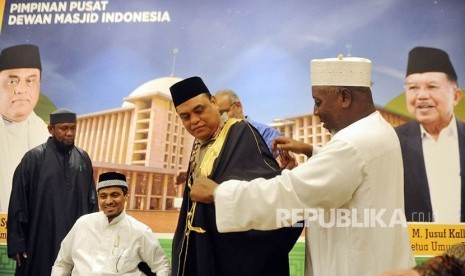 Wakil Ketua Dewan Masjid Indonesia yang juga menjabat Wakapolri Komisaris Jenderal Pol Syafruddin  menerima baju gamis dari ulama Mekkah, Saudi Arabia, Syekh Kahlid Al Hamoudi saat pertemuan di kantor DMI Pusat, Jakarta, Senin (2/4). 