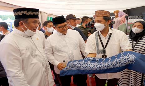 Wakil Ketua DPR Rahmat Gobel (kiri) bersama Kepala Perwakilan (KPw) Bank Indonesia (BI) Provinsi Sulawesi Selatan Causa Iman Karana (tengah) melihat kain sulam Karawo pada Festival Produk Halal Milenial di Lapangan Ippot, Kabupaten Bone Bolango, Gorontalo, Sabtu (26/3/2022). Bank Indonesia menggelar Festival Produk Halal Milenial untuk mendorong akselerasi pengembangan ekonomi dan keuangan syariah nasional menjelang Indonesia Shari