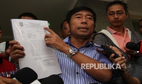 Wakil Ketua DPRD DKI Jakarta Abraham Lunggana alias Haji Lulung (kanan) menunjukkan surat hasil evaluasi anggaran perubahan daerah dari Kemendagri kepada wartawan saat tiba di Bareskrim Mabes Polri, Jakarta, Kamis (25/2). 