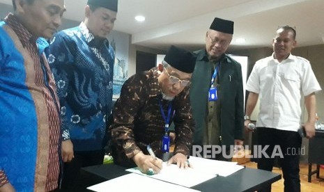  Wakil Ketua Harian Forum Komunikasi Bimbingan Ibadah Haji (FKBIH), Oman Syahroni (batik cokelat) dan Kasubdit Bimbingan Jemaah Haji Kemenag, Endang Jumali (batik biru kopyah hitam) saat menandatangi fakta integritas terkait pedoman kurikulum pelaksanaan manasik haji di Jakarta, Kamis (22/3).