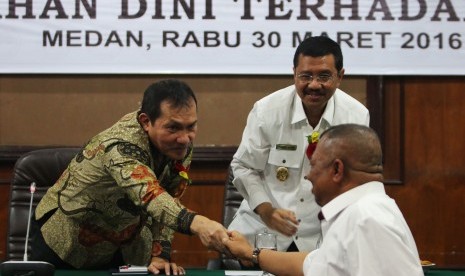 Wakil Ketua Komisi Pemberantasan Korupsi (KPK) Saut Situmorang (kiri) disaksikan Plt Gubernur Sumatra Utara T Erry Nuradi (kanan) menyalami mantan Gubernur Sumatra Utara Syamsul Arifin di sela-sela Seminar Pencegahan Dini Terhadap Korupsi di Medan, Sumatra