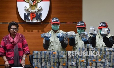 Wakil Ketua KPK Basaria Panjaitan (kiri) memperhatikan penyidik KPK memperlihatkan barang bukti uang yang disita KPK dari pengembangan operasi tangkap tangan KPK terhadap Wali Kota Kendari Adriatma Dwi Putra dan ayahnya calon gubernur Sultra Asrun di gedung KPK, Jakarta, Jumat (9/3). 