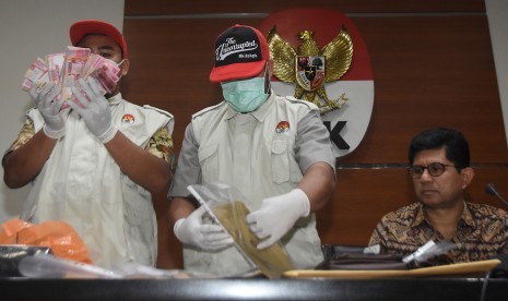 Wakil Ketua KPK Laode M. Syarief (kanan) bersama penyidik menunjukkan barang bukti hasil OTT kasus dugaan suap terkait seleksi pengisian jabatan pimpinan tinggi di Kementerian Agama saat konferensi pers di gedung KPK, Jakarta, Sabtu (16/3).