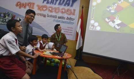 Wakil Ketua KPK Laode M. Syarif (kedua kiri) bersama anak-anak sekolah bermain dalam peluncuran Playday Boardgames Anti Korupsi di KPK, Jakarta, Jumat (15/4). (Antara/Rosa Panggabean)