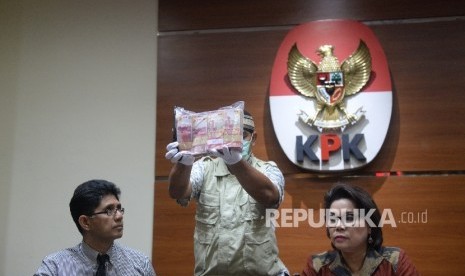 Wakil Ketua KPK Laode M Syarif (kiri) dan Basaria Panjaitan (kanan) bersama penyidik KPK menunjukkan uang barang bukti hasil OTT di Gedung KPK, Jakarta, Selasa (6/6).