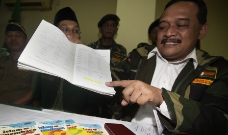 Wakil Ketua Umum GP Ansor Benny Rhamdani menunjukkan tulisan yang berbunyi 