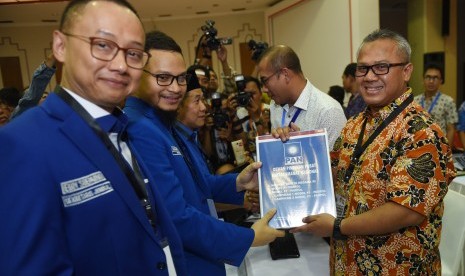 Wakil Ketua Umum PAN Hanafi Rais (kedua kiri) didampingi Sekjen Eddy Soeparno (kiri) menyerahkan berkas pendaftaran partai kepada Ketua KPU Arief Budiman (kanan) di KPU Pusat, Jakarta, Jumat (13/10). PAN secara resmi mendaftar sebagai peserta Pemilu 2019. 