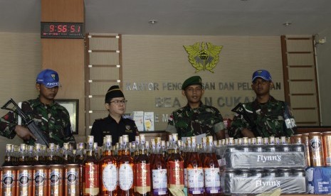 Wakil Komandan Satgas Pengamanan Perbatasan Yonif 521/Dadaha Yudha, Kapten Inf Alisun (kedua kanan) dan jajarannya secara simbolis menyerahkan minuman keras (miras) hasil sitaan kepada Kepala Bea & Cukai Nunukan, Max Rori (kedua kiri) di Kantor BC Kabupate