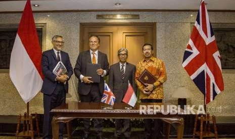 Wakil Menteri Luar Negeri A. M. Fachir (kedua kanan) bersama Duta Besar Inggris untuk Indonesia Moazzam Malik (kiri), Menteri Muda Urusan Asia Pasifik Kemlu Inggris Y.M Mark Field (kedua kiri) dan Kepala Badan Siber dan Sandi Negara Djoko Setiadi (kanan) berfoto bersama usai menandatangani MoU di Kementerian Luar Negeri, Jakarta, Selasa (14/8). 