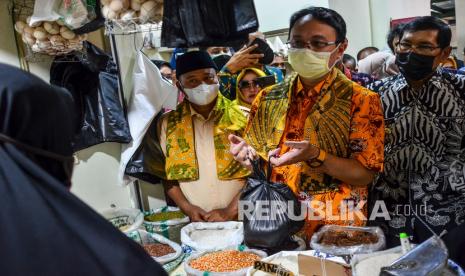 Wakil Menteri Perdagangan Jerry Sambuaga (tengah) didampingi Wakil Gubernur Jawa Barat Uu Ruzhanul Ulum (kiri) dan Wali Kota Tasikmalaya Muhammad Yusuf (kanan) membeli beras di Pasar Rakyat Pancasila, Kota Tasikmalaya, Jawa Barat, Sabtu (22/1/2022). Dalam kunjungannya Jerry Sambuaga meresmikan pasar rakyat Pancasila yang sudah direvitalisasi dari bantuan Pemerintah Provinsi Jawa Barat senilai Rp15 miliar dan sekaligus meninjau harga kebutuhan pokok. 